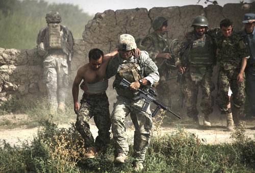 During a rescue mission by a team from a U.S. Air Force Expeditionary Rescue Squadron, a U.S. soldier helps an Afghan Army soldier in southern Afghanistan, Monday Aug. 2, 2010. (AP)