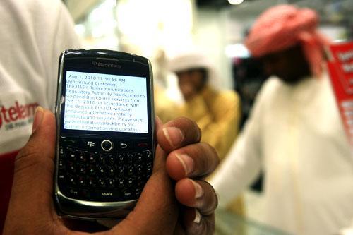 A BlackBerry user displays a text message sent by his service provider notifying him of the suspension of services, at a mobile shop in Dubai, Aug. 5, 2010 (AP)