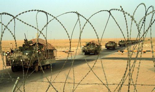 A column of U.S. Army Stryker armored vehicles cross the border from Iraq into Kuwait Wednesday. (AP )