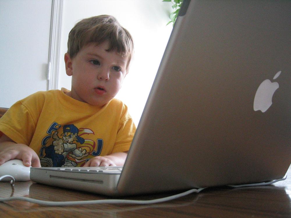 A child uses a laptop computer. (Todd Hiestand/Flickr)