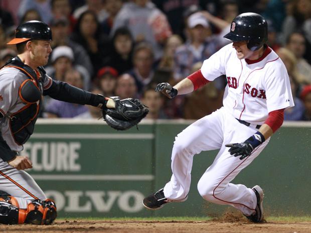 Boston Red Sox's Jed Lowrie, right, gets caught trying to steal home by Baltimore Orioles catcher Matt Wieters after a strikeout by Jason Varitek in the sixth inning of the baseball game at Fenway Park in Boston on Monday. (AP)