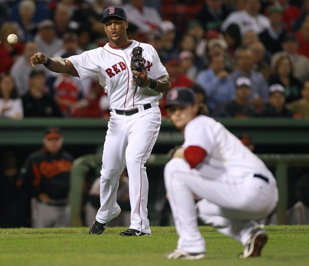 Boston Red Sox pitcher Clay Buchholz, right, ducks out of the way as third baseman Adrian Beltre throws out Baltimore Orioles' Adam Jones on a sacrifice bunt during the second inning of a baseball game at Fenway Park in Boston on Tuesday. (AP)