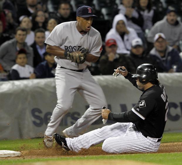 Chicago White Sox's Carlos Quentin slides under the throw to Boston Red Sox's third baseman Adrian Beltre in the third inning of a baseball game on Monday in Chicago.  Quentin got pushed to third by Alexei Ramirez's double. (AP Photo/John Smierciak)