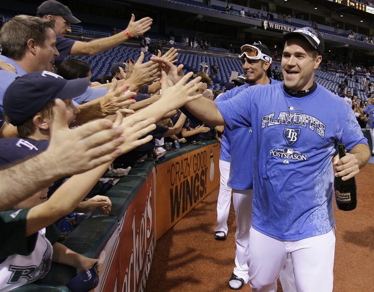 Tampa Bay Rays' Kelly Shoppach, right, and Matt Garza celebrate with fans after the Rays clinched a playoff berth. (AP)