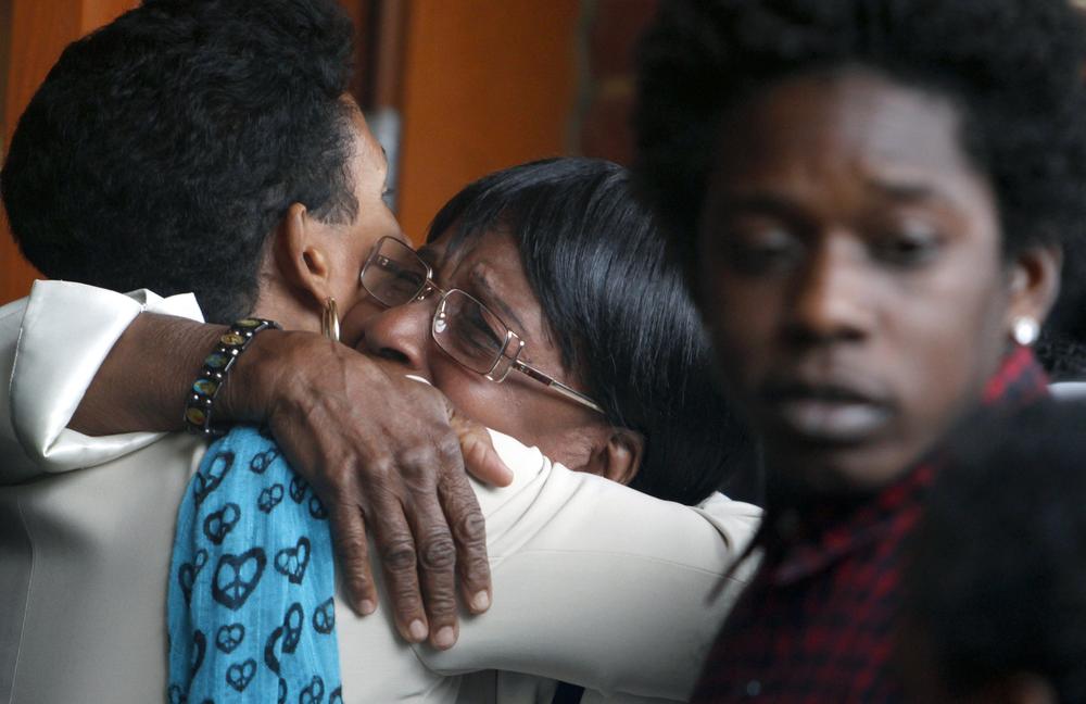 Mourners hug outside the Morning Star Baptist Church in Mattapan Wednesday following a funeral service for Eyanna Flonory and her son 2-year-old son Amani Smith. (AP)