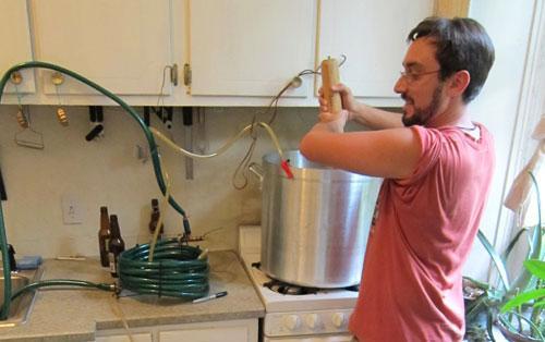 Jamie Darnton, of Philadelphia, cooling hopped wort to room temperature in a counterflow chiller, as it is syphoned into the primary fermenter.