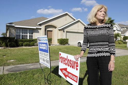 Realtor Dorothy Buse stands in front of a foreclosed home in Kissimmee, Fla., Oct. 6, 2010. (AP)