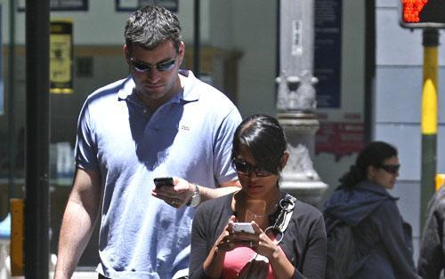 A couple text message while walking in San Francisco, June, 29, 2010. (AP)