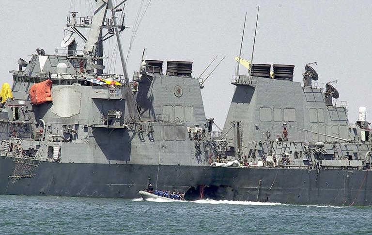 Experts in a speed boat examine the hull of the USS Cole  at the Yemeni port of Aden on Oct. 15, 2000. A powerful explosion a few days earlier ripped a hole in the U.S Navy destroyer in the Yemeni port, killing 17 sailors and injuring some 30 others. (AP)