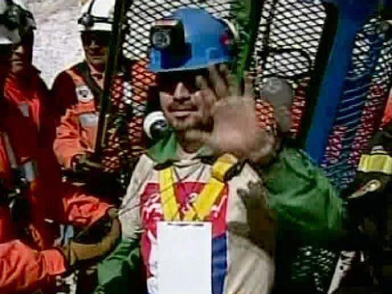 In this screen grab taken from video, miner Edison Pena waves after being rescued from the collapsed San Jose gold and copper mine.  (AP)