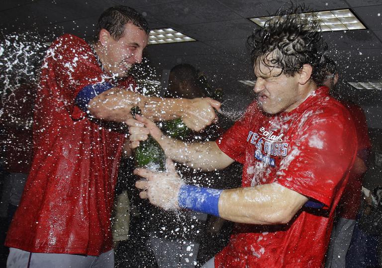 Texas Rangers' Ian Kinsler, right, gets sprayed with champagne while celebrating his team's advance to the ALCS. (AP)