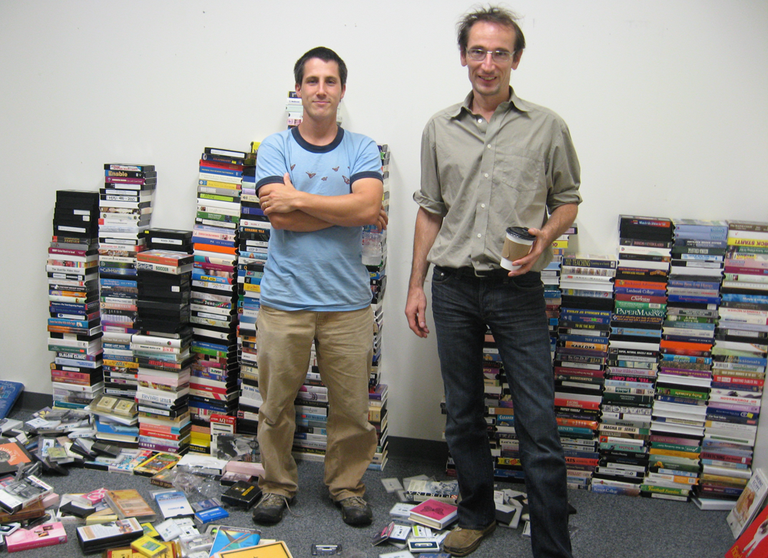 The Books &mdash; Nick Zammuto, left, and Paul de Jong &mdash; with their collection of randomly discovered cassettes, LPs and videotapes. (Andrea Shea/WBUR)