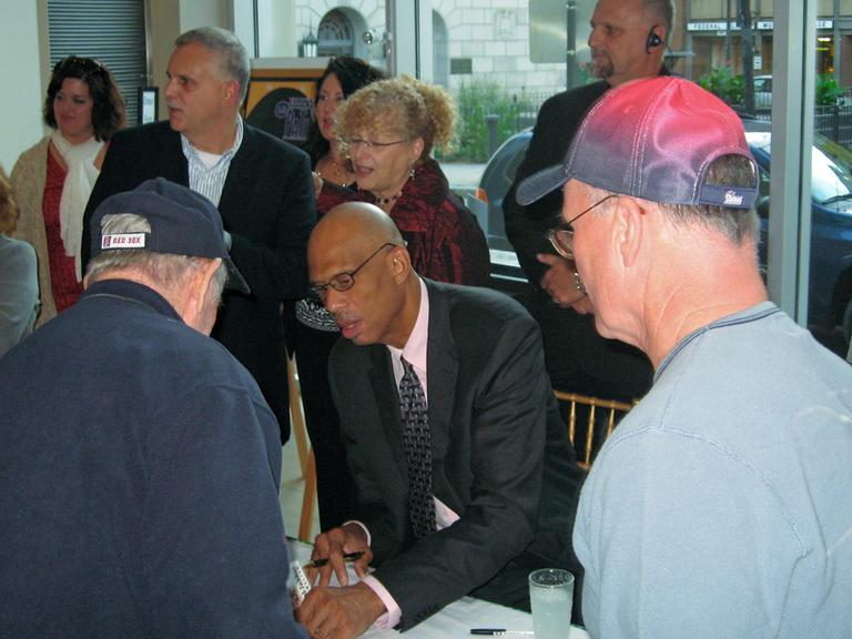Kareem Abdul-Jabbar, the author, signing copies of his book, in Worcester. (Bill Littlefield/WBUR)