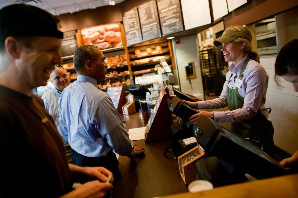Gov. Deval Patrick, center, ordered a grilled chicken salad from cashier Laura Murphy at Panera Bread in Boston. Patrick sat down with WBUR's Bob Oakes, background, on Tuesday. (Dominick Reuter for WBUR)