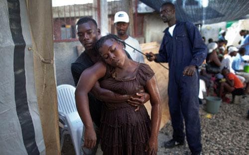 A worker sprays with disinfectant a woman with symptoms of cholera in Cite Soleil in Port-au-Prince, Haiti, November 10, 2010. (AP)