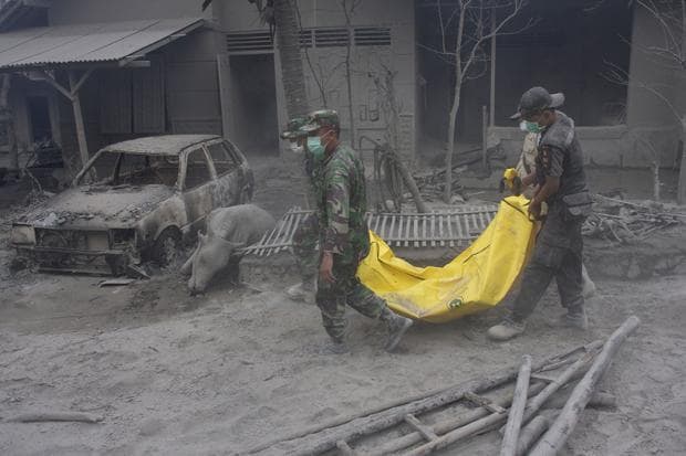 Rescuers carry the body of a victim of Mount Merapi eruption in Argomulyo, Yogyakarta, Indonesia on Friday. A deadly surge of blistering gases cascaded down the slopes of Indonesia's most volatile volcano, torching houses in one mountainside village. (AP)