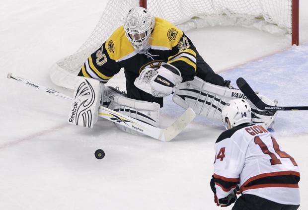 Boston Bruins goalie Tim Thomas drops to the ice to make a save against New Jersey Devils right wing Stephen Gionta, right, during the third period of an NHL hockey game in Boston on Monday. The Bruins shut out the Devils 3-0. (AP)