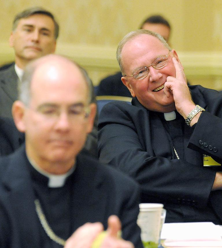 Archbishop Timothy Dolan, right, of New York, reacts after being elected president of the U.S. Conference of Catholic Bishops on Tuesday in Baltimore. (AP) 