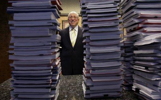 Lawyer Peter Ticktin, of The Ticktin Law Group poses behind stacks of depositions from 150 robosigners, alleging that the court documents reveal an industry-wide banking scheme to defraud homeowners, in Deerfield Beach, Fla. (AP)