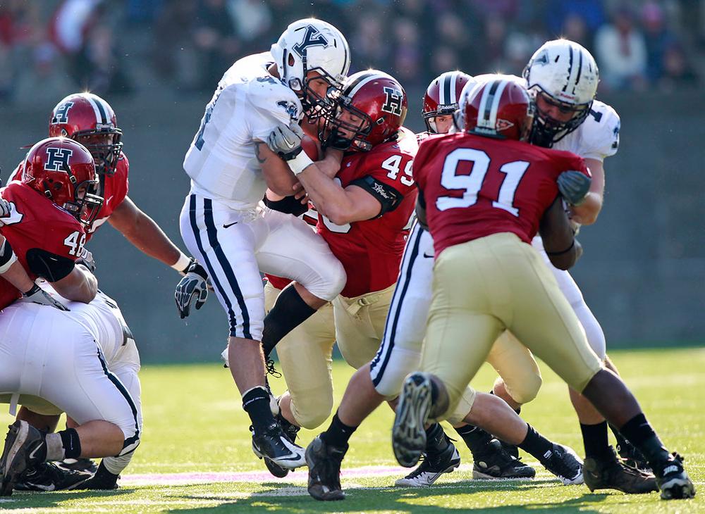 Yale Bulldogs running back Alex Thomas is stopped by Harvard Crimson line backer Alex Gedeon during the first half of The Game on Saturday. (Greg M. Cooper/AP)