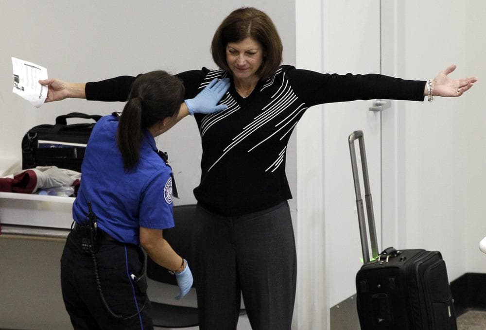 A woman undergoes a pat-down during TSA security screening, Friday, at Seattle-Tacoma International Airport in Seattle. (AP Photo/Ted S. Warren)