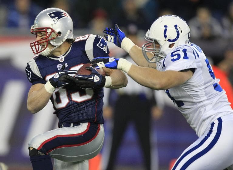 New England Patriots wide receiver Wes Welker, left, eludes Indianapolis Colts line backer Pat Angerer, right, as he heads to the end zone for a touchdown during the first quarter of the game on Sunday. (AP)