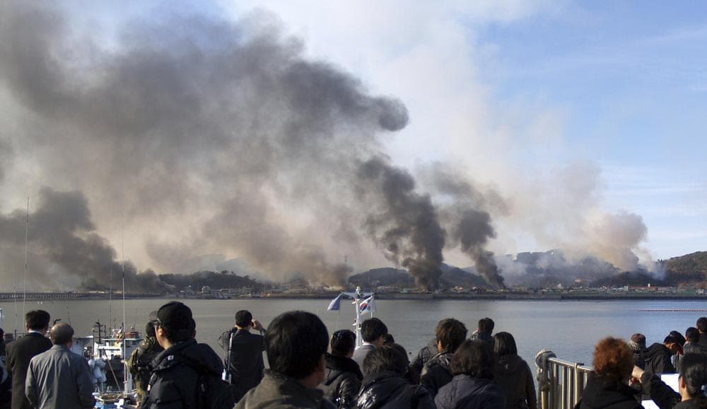 South Korean villagers watch smoke rising from South Korea's Yeonpyeong island near the border against North Korea Tuesday. (AP)