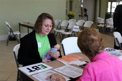 Volunteer Evelyn Williams calculates the groceries she can offer Jinjer Taylor, principal of Woody Gap high school/elementary school, playing an impoverished mother using food stamps in a poverty simulation in Gainesville, Ga. (AP)