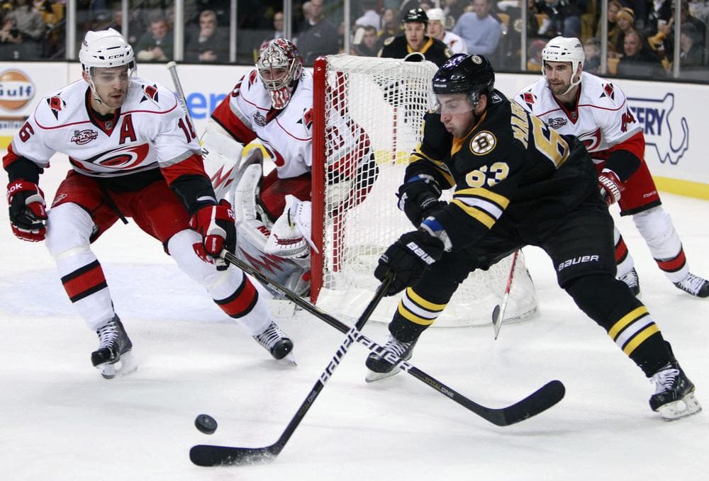  Bruins' Brad Marchand (63) tries to gain  control of the puck as Carolina Hurricanes' Brandon Sutter, left, defends in the second period , Friday, in Boston. (AP Photo/Michael Dwyer)