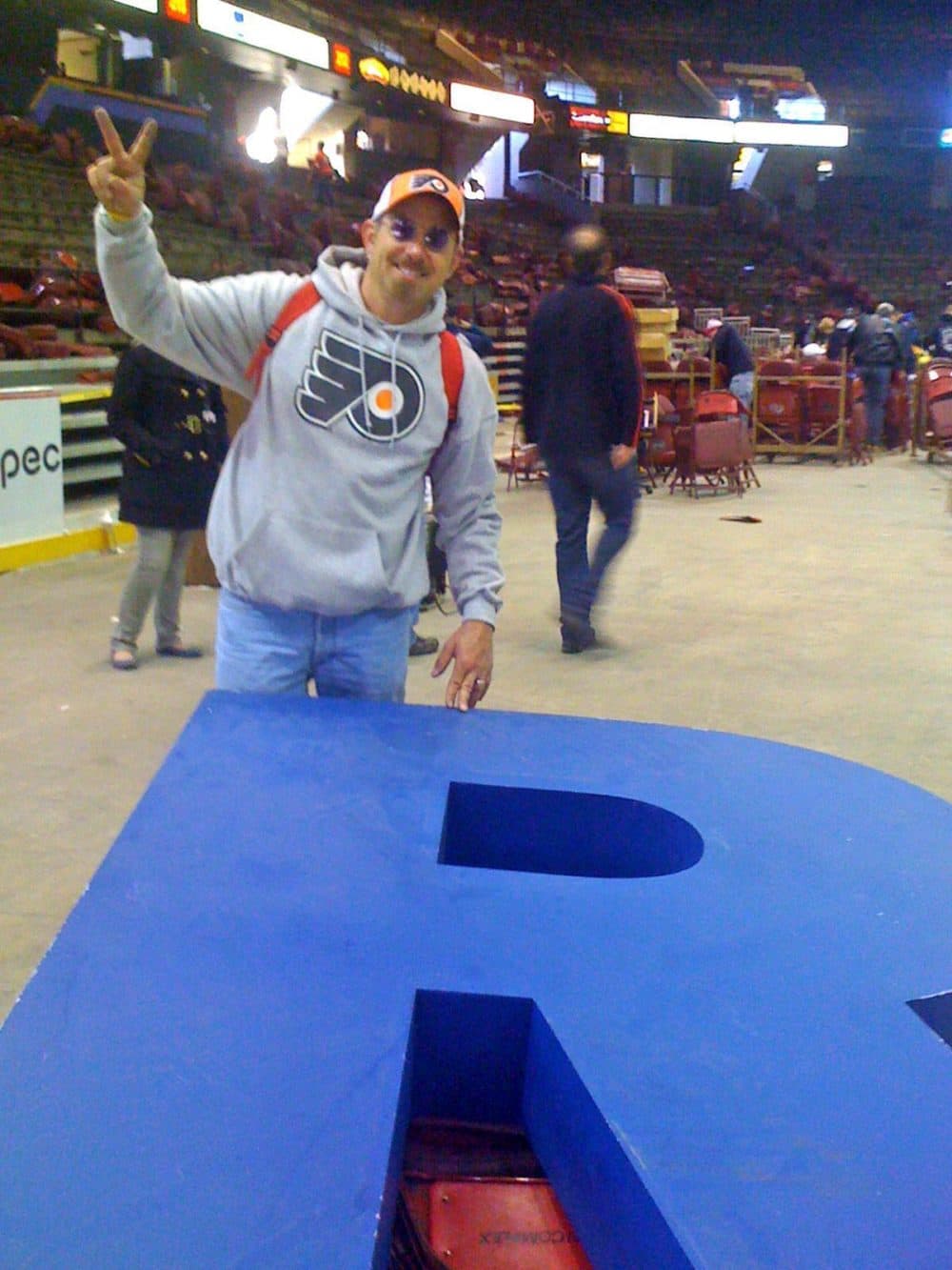 A Flyers fan poses on the floor of the Philadelphia Spectrum. Last weekend, Philadelphians lined up to take whatever they could carry from the old arena before it was demolished.