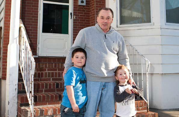 Buddy Wilson with his grandsons outside the East Boston home Boston Community Capital helped him afford. (Courtesy photo)