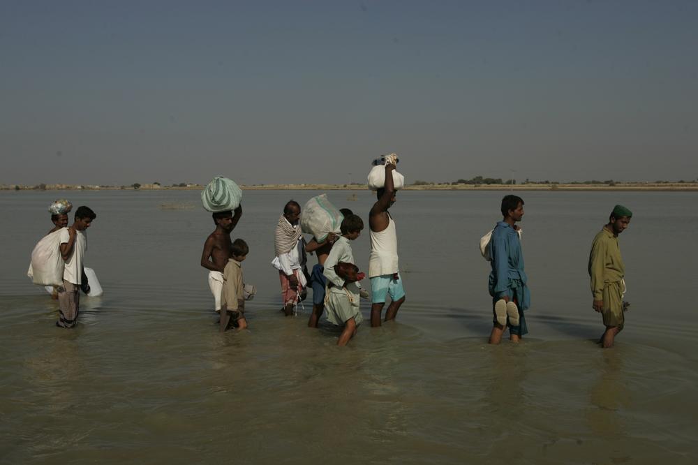Survivors in Pakistan wade through water in their village of Khairpur Nathan Shah, which is still surrounded by floodwaters, months after floods hit the country, claiming 2,000 lives and affecting 20 million people. (AP)