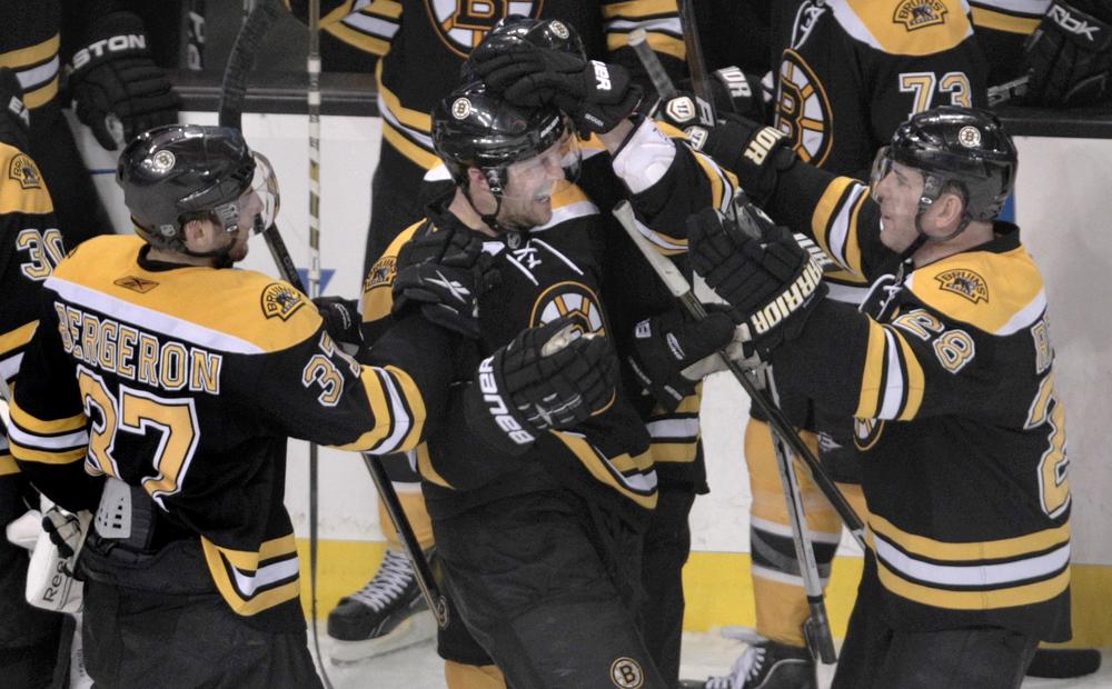 Boston's right wing Mark Recchi, right, is congratulated by teammates Dennis Seidenberg, center, and Patrice Bergeron after scoring the game-winning goal off Buffalo's Ryan Miller during overtime the game in Boston on Tuesday. The Bruins beat the Sabres 3-2. (AP) 