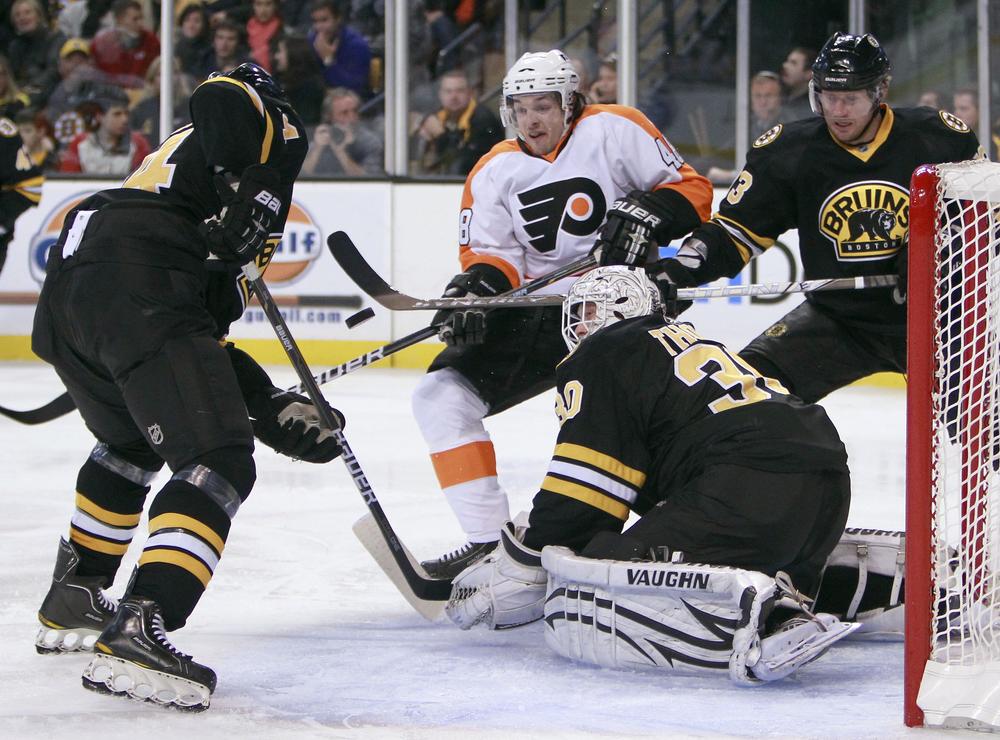 Philadelphia Flyers&#39; Danny Briere, (48) looks for the rebound as Boston Bruins&#39; Dennis Seidenberg, left,  moves to clear the puck from in front of Bruins goalie Tim Thomas (30) in the third period, Saturday, in Boston. (AP)