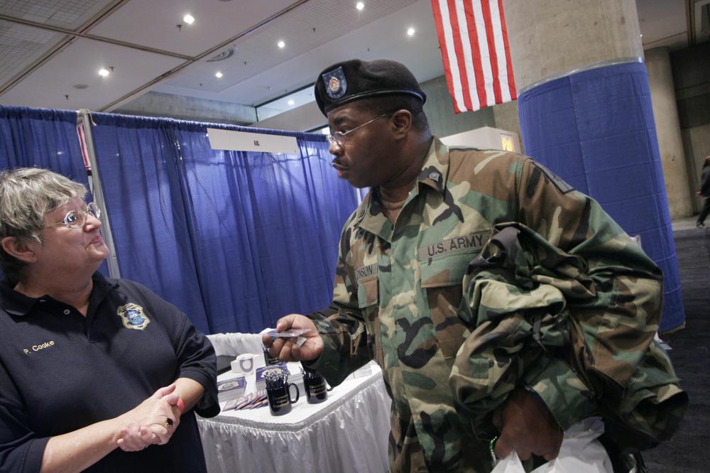 James Johnson, a 22-year Army veteran, talks with Pat Cooke, left, a recruiter for the Clearwater, Fla. police department, at a veterans job fair in New York. (AP)