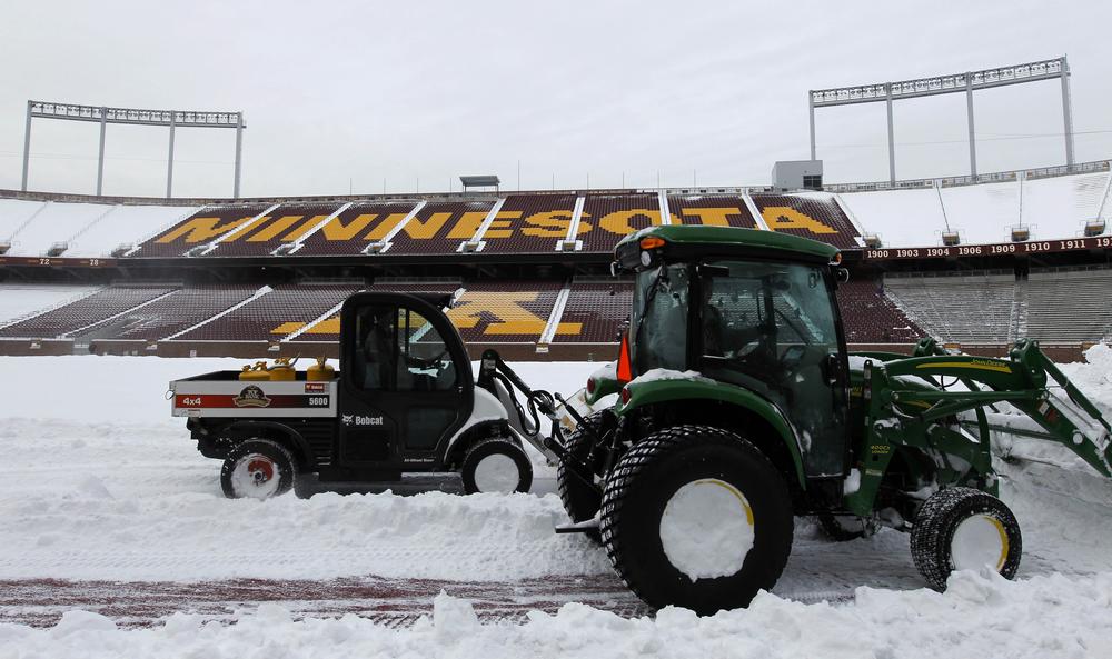 Workers clear snow from TCF Bank Stadium at the University of Minnesota in Minneapolis. (AP)