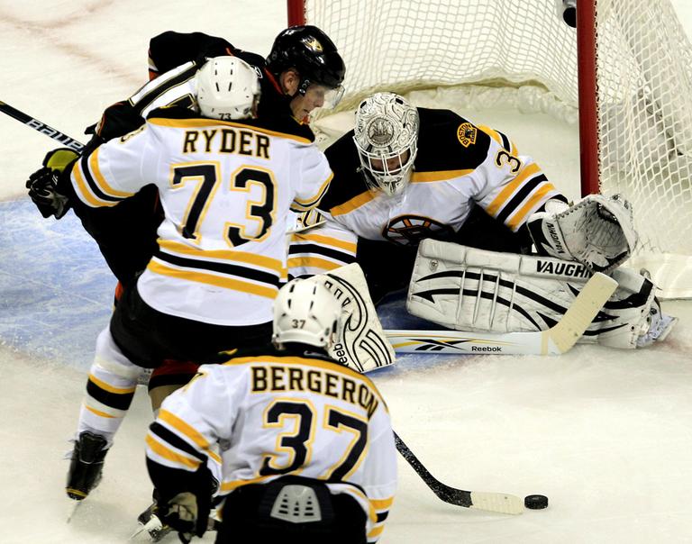 Boston goalie Tim Thomas, left, drops his stick to the ice as Anaheim right wing Corey Perry shoots during the second period of the game in Boston on Monda. Clearing Perry from the crease is Bruins right wing Michael Ryder. (AP)