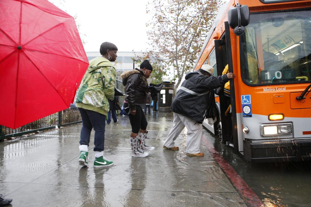 Pedestrians walk through rising water as they catch a city  bus in  Los Angeles. (AP)