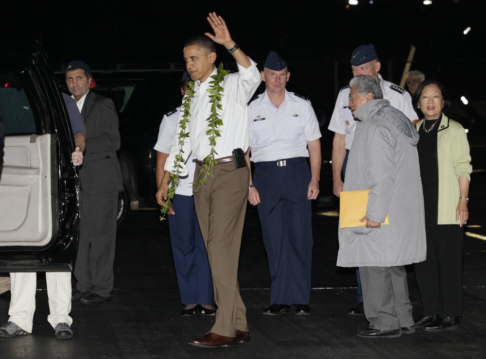 President Barack Obama waves after deplaning from Force One as he arrives at Hickam Air Force Base in Honolulu. (AP)