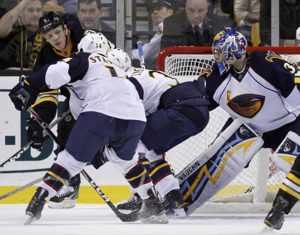 Boston's Shawn Thornton, behind left, tries to get the puck into the net past Atlanta's Tim Stapleton (14), Tobias Enstrom, center, of Sweden, and goalie Ondrej Pavelec, right, of the Czech Republic, in the third period of the game on Thursday in Boston. The Bruins won 4-1. (AP)