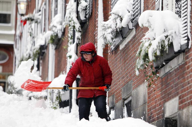 Janeth Gonzalez shovels snow on Beacon Hill in Boston, Monday. (AP)
