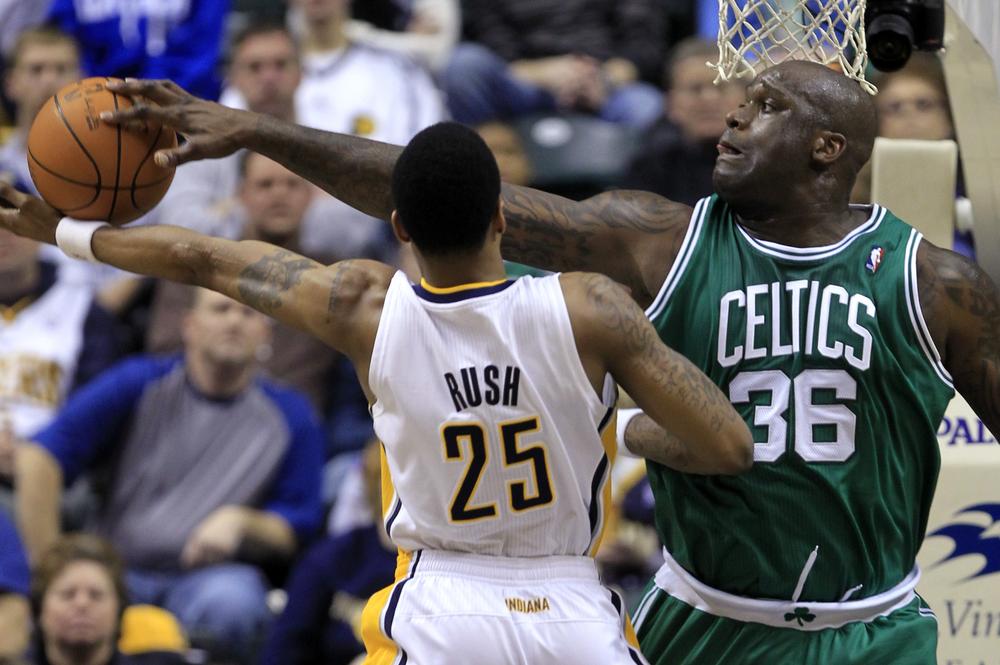 Boston center Shaquille O'Neal, right, blocks the shot of Indiana guard Brandon Rush in the first half of the game in Indianapolis on Tuesday. (AP)