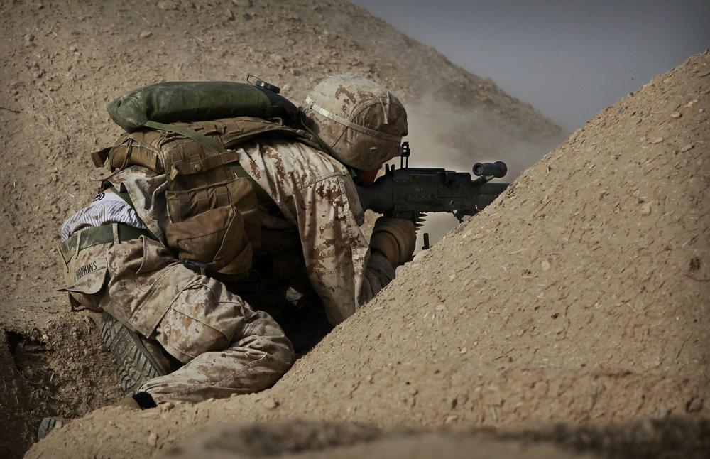 United States Marine Cpl. Jesse Hopkins from Bravo Company of the 1st Battalion of the 2nd Marines fires a machine gun during a gun battle as part of an operation to clear the area of insurgents near Musa Qaleh, in northern Helmand Province, southern Afghanistan in 2010. (AP)