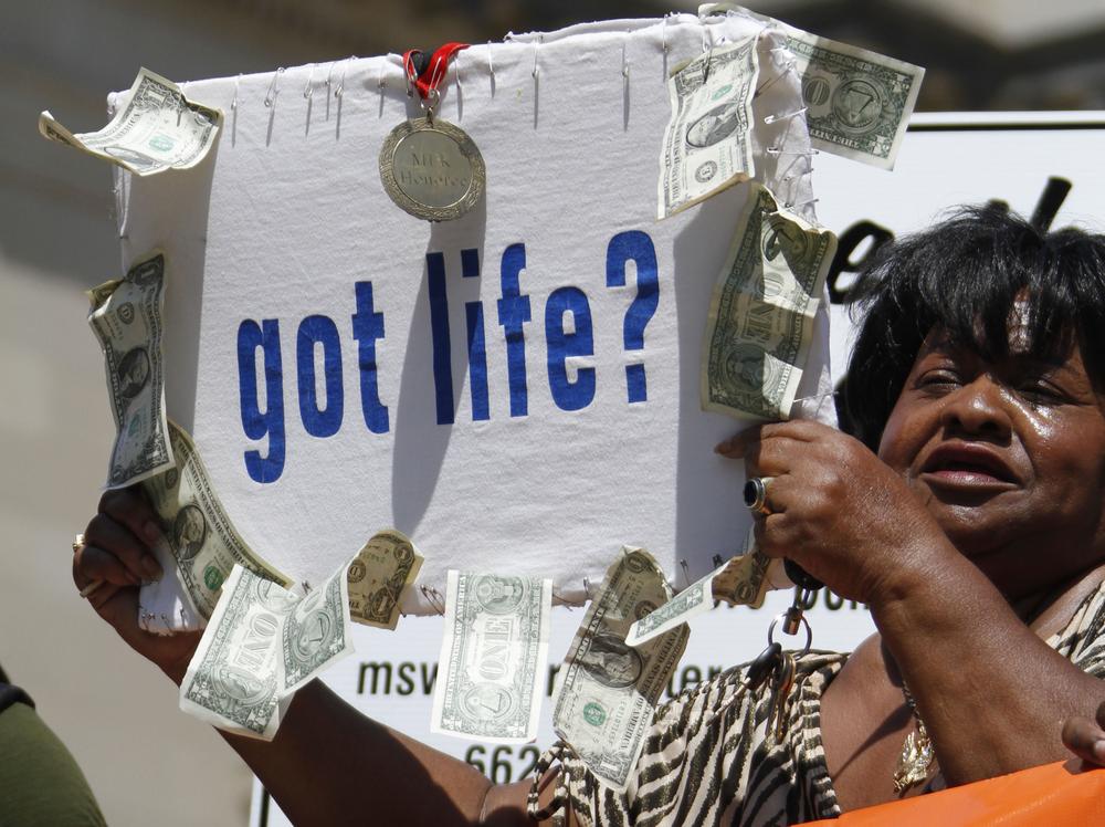 Civil rights activist Dorothy Benford of Jackson, waves a sign with $11 in singles hanging from it to protest the life sentences Jamie and Gladys Scott received for a robbery that netted that same amount, during a rally at the Capitol in Jackson, Miss., in September. (AP)