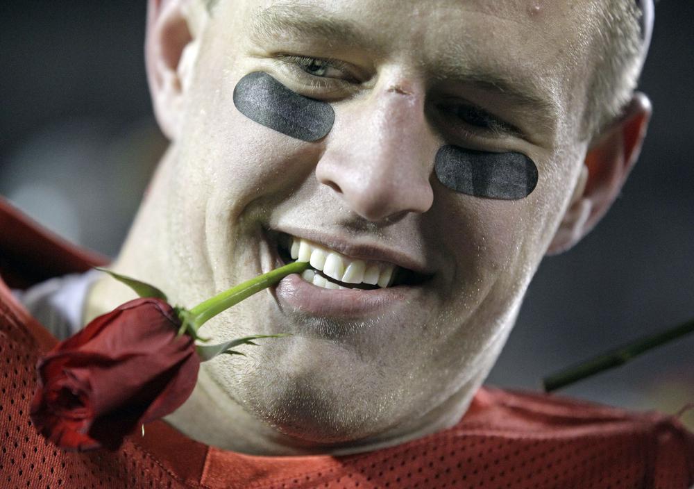 Wisconsin defensive tackle J.J. Watt bites a rose after beating Northwestern to secure Wisconsin&#039;s spot in the Rose Bowl. (AP Photo/Morry Gash)
