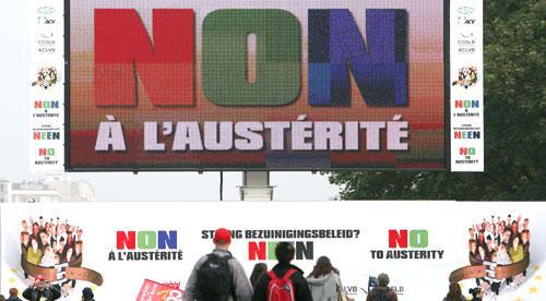Protestors walk past a billboard which reads &#039;No to austerity&#039; during a demonstration in Brussels, 2010. (AP)