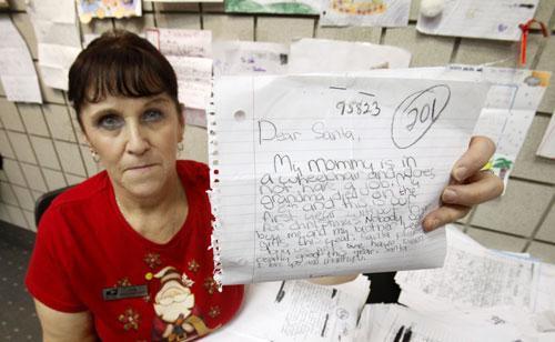 U. S. Postal Service employee Rita Rose displays one of thousands of “Dear Santa” letters that her office handles in Sacramento, Calif., Dec. 15, 2010. (AP)