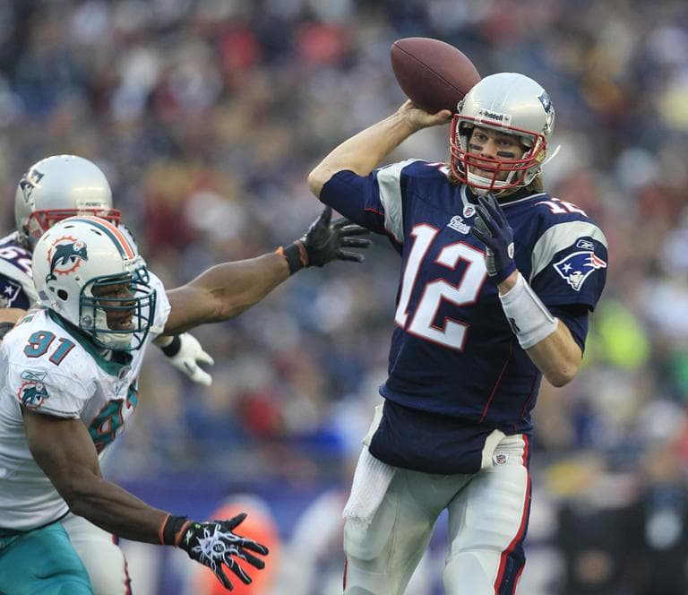 New England quarterback Tom Brady sets to throw as Miami linebacker Cameron Wake pressures him during the second quarter of the game in Foxborough on Sunday. (AP)