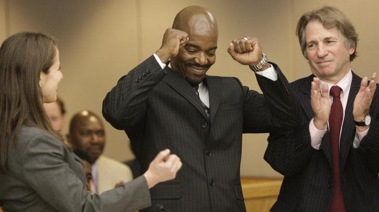 Cornelius Dupree Jr., center, raises his hands in celebration with his lawyer Nina Morrison, left, and attorney Barry Scheck in Dallas on Tuesday, Jan. 4, 2010. (AP)