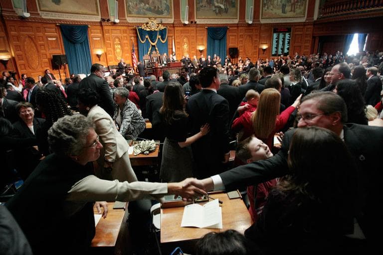 Members of the House and their families and friends wish congratulations after being sworn-in to office in the House Chambers at the State House Wednesday. (AP)